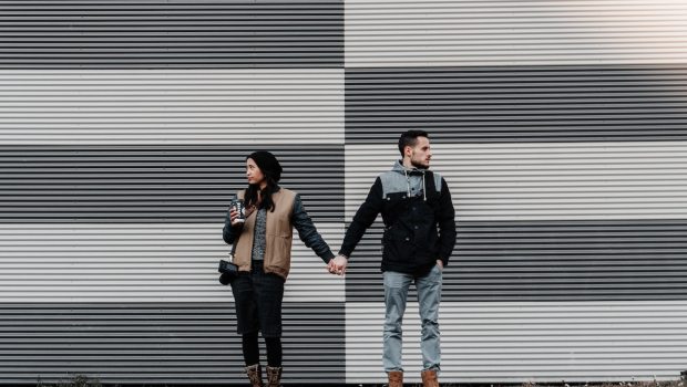 couple holding hands not looking at each other