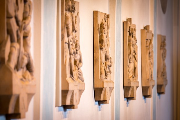 Drewniane stacje drogi krzyżowej na ścianie kościoła