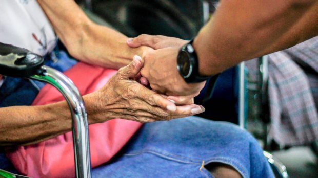 man holds old woman's hands