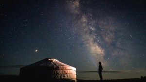 Człowiek patrzy na usiane gwiazdami nocne niebo