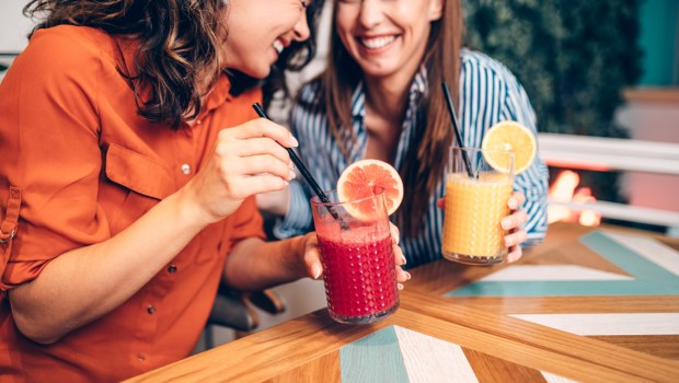 dwie przyjaciółki śmieją się podczas spotkania w restauracji