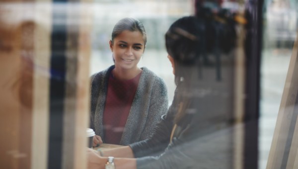Kobieta z przyjaciółką rozmawiają w kawiarni