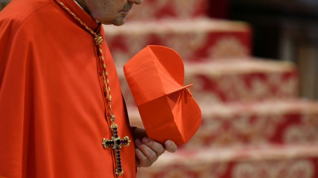 kardynał trzyma w ręce biret
