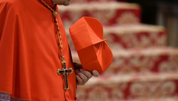 kardynał trzyma w ręce biret