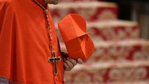 kardynał trzyma w ręce biret