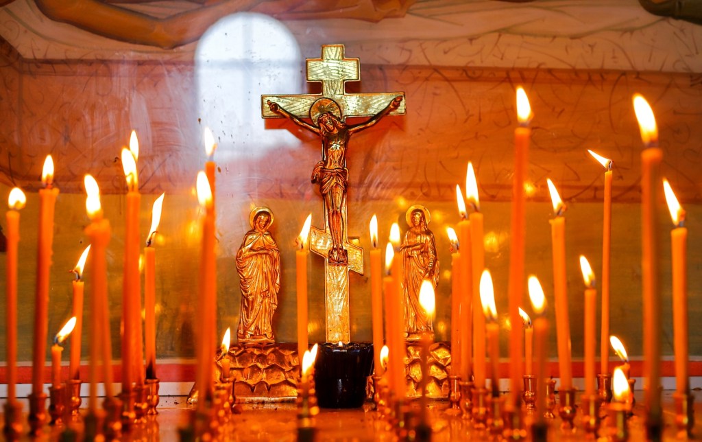 Krzyż prawosławny pośród świec
