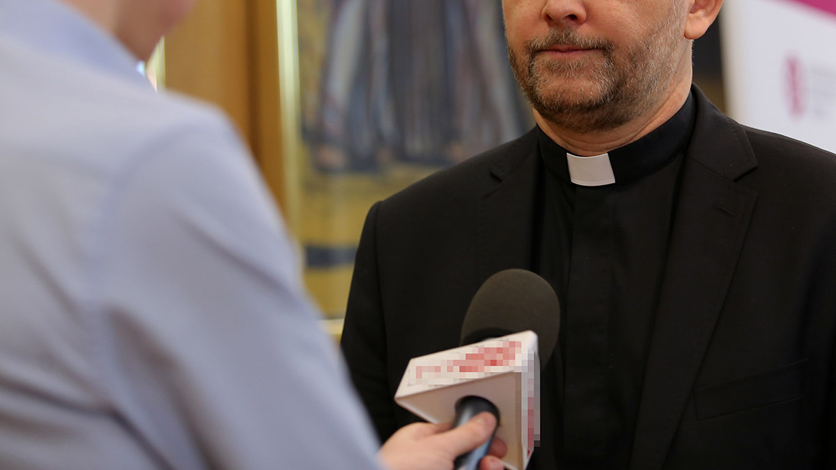 Ksiądz katolicki udziela wypowiedzi dla telewizji