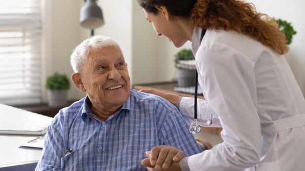 Pielęgniarka uśmiecha się do starszego pacjenta