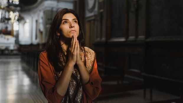 kobieta modli się wewnątrz kościoła