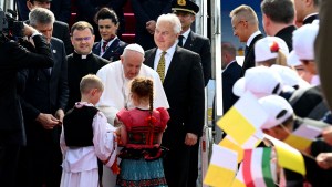 Pope Francis is greeted by children wearing traditional Hungarian dresses after he arrived