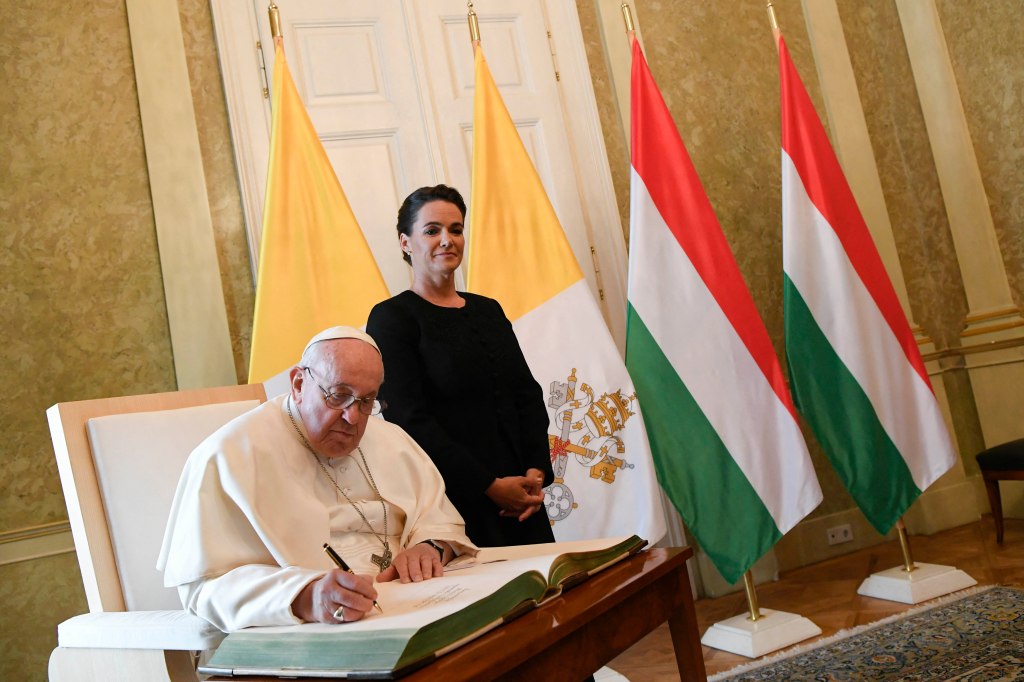 Pope Francis signing the Golden Book next to Hungary's President Katalin Novak in Budapest on April 28