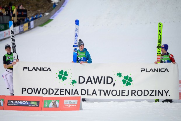 Skoczkowie w Planicy z transparentem wspierającym Dawida Kubackiego