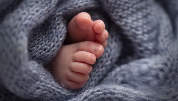 Stopy noworodka zawiniętego w ciepły kocyk