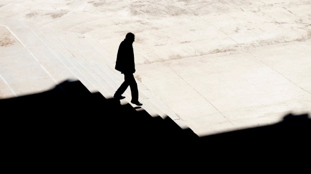 Sylwetka mężczyzny idącego po schodach w mieście