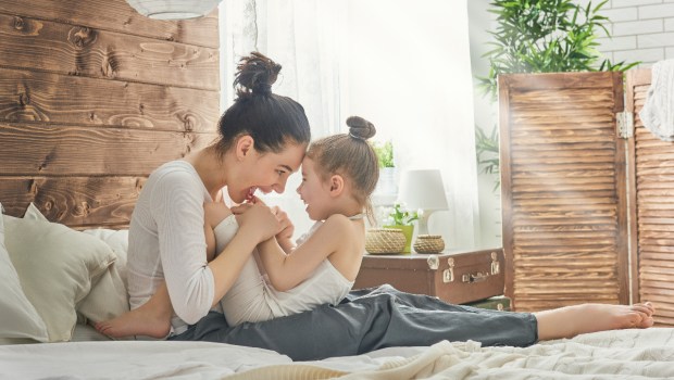 Mama bawi się z dzieckiem na łóżku