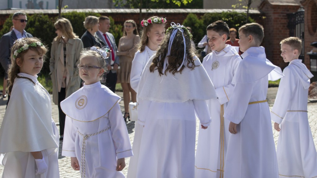 Dzieci przed kościołem podczas pierwszej Komunii świętej