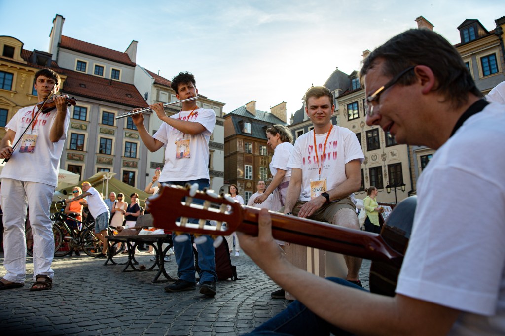 Ludzie grający i śpiewający na rynku miasta