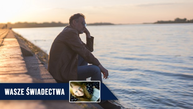 Mężczyzna siedzi samotnie nad brzegiem rzeki