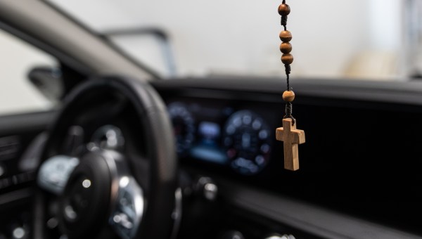 Drewniany krzyżyk i różaniec wiszący wewnątrz samochodu