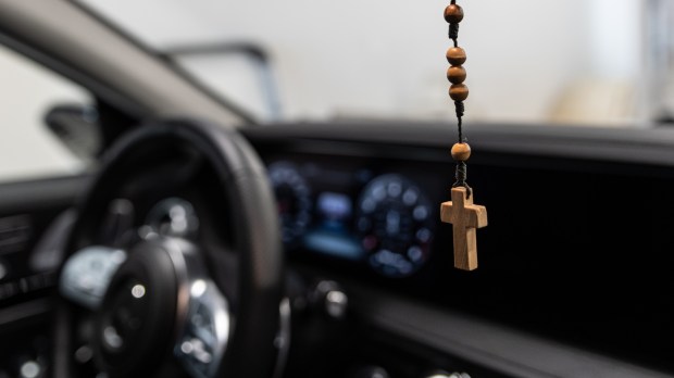 Drewniany krzyżyk i różaniec wiszący wewnątrz samochodu
