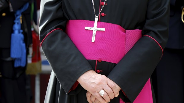 Biskup trzymający złożone ręcę
