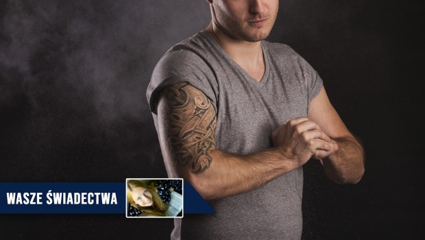 Umięśniony i wytatuowany mężczyzna stoi w zadymionym studiu fotograficznym