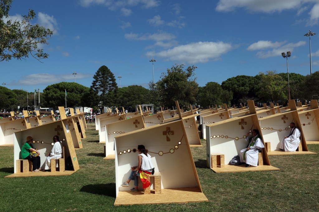 Pilgrims confess in an open confessionals area in Belem, Lisbon, during the World Youth Day