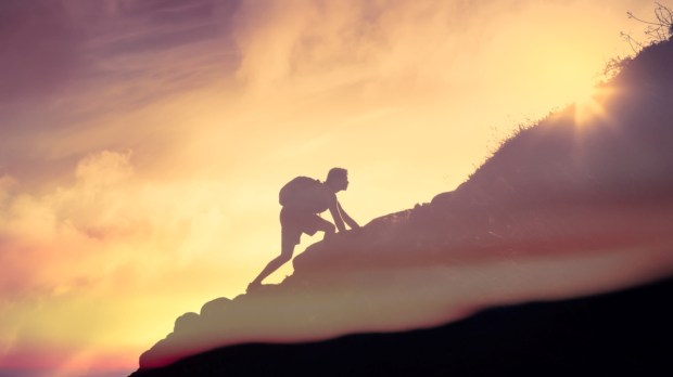 Man climbing up a mountain. Motivation, and inspiration concept