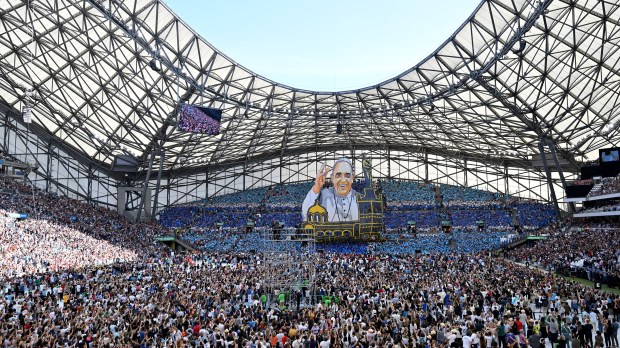 Supporters of the Olympique de Marseille football club hold up a huge banner of Pope Francis as he arrives to celebrate mass at the Velodrome stadium in the southern port city of Marseille