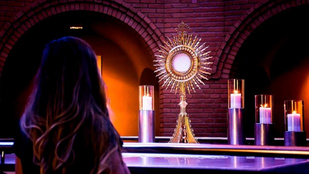 Kobieta podczas adoracji Najświętszego Sakramentu