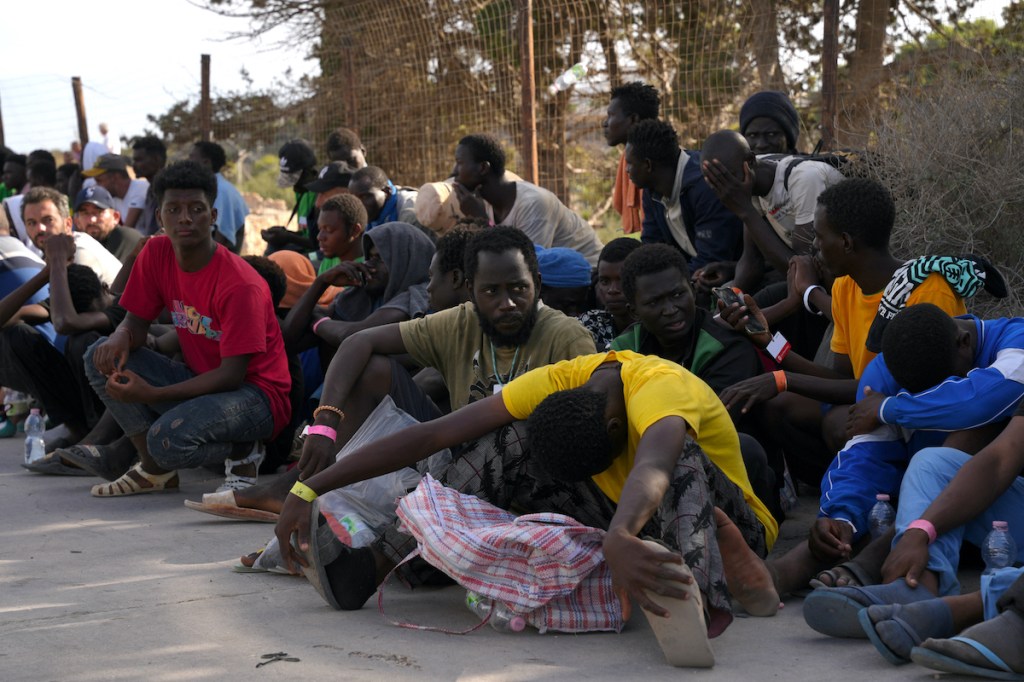 Des migrants sont assis dans le port de l'île italienne de Lampedusa, le 16 septembre 2023.