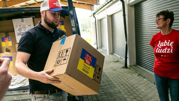 Wolontariusze przepakowują paczki przygotowane w ramach akcji Solidarna Paczka