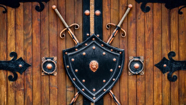 Tarcza i miecze na drewnianej bramie