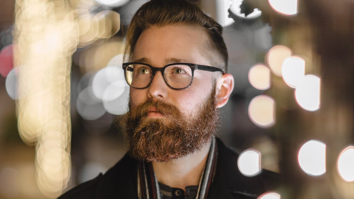 Portret brodatego mężczyzny na rozświetlonej nocą ulicy