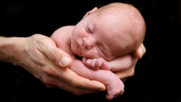 Noworodek trzymany na ręce