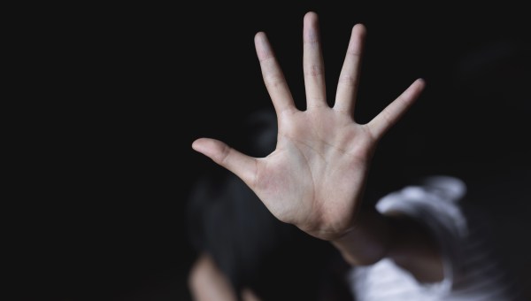 Dziewczyna wyciąga dłoń w geście obrony