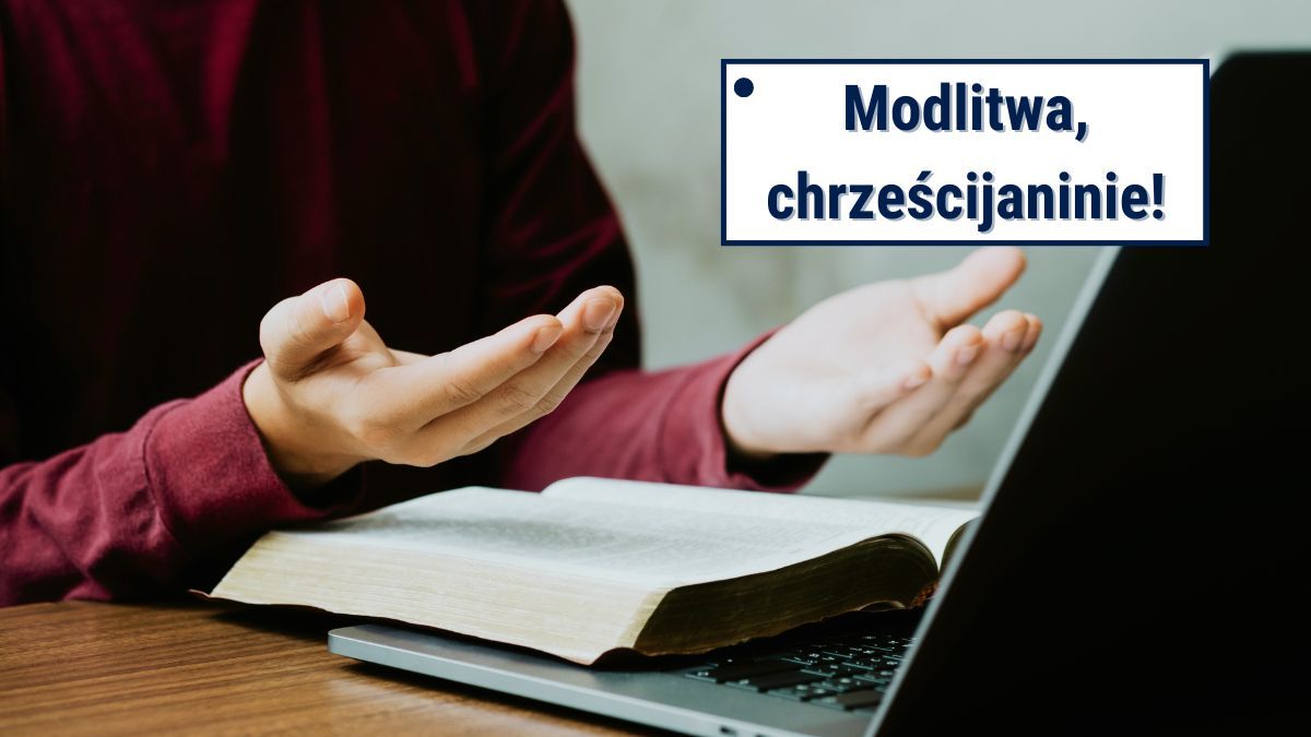 Człowiek modli się mając przed sobą otwarte Pismo Święte i laptopa