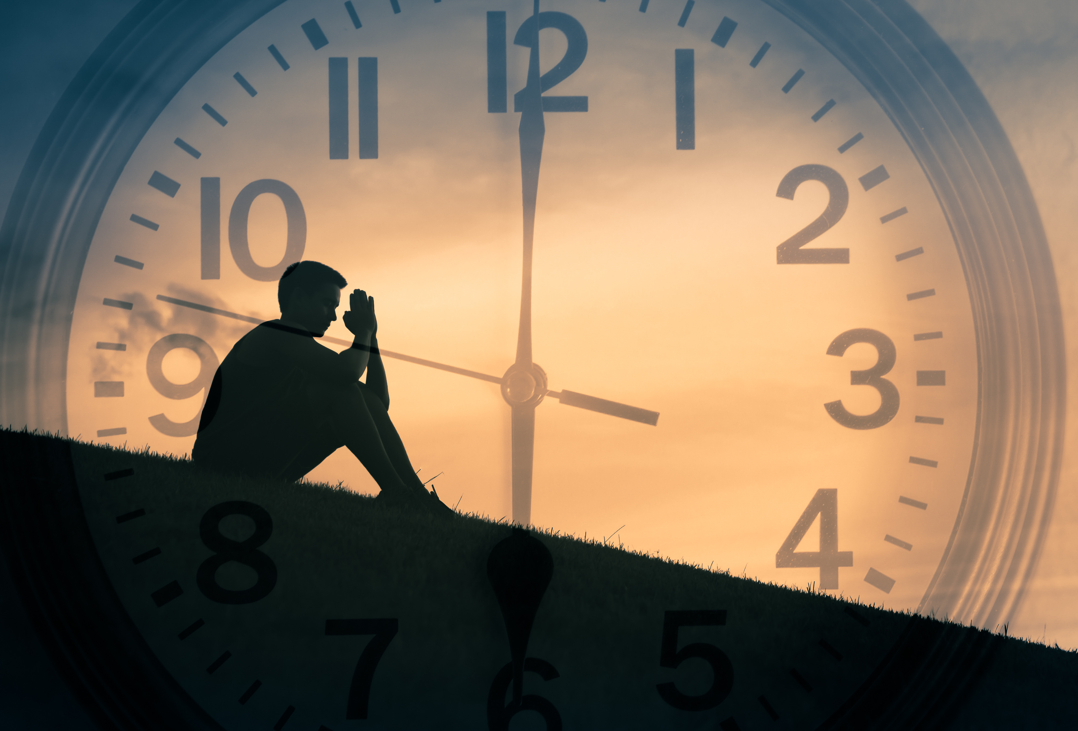 Mężczyzna modli się na tle zegara