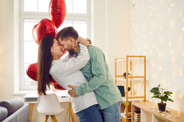 Happy young couple hugging and kissing at home
