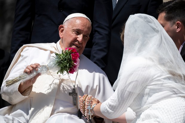 A newlywed bride gives Pope Francis a bouquet of flowers at the end of the General Audience in St. Peter's Square on Wednesday, June 12, 2024.