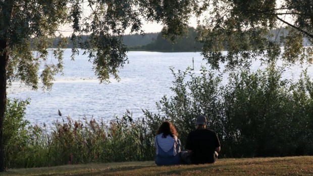 Para rozmawiająca nad brzegiem jeziora
