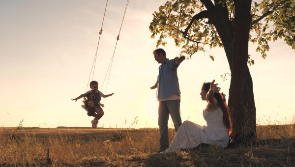 Szczęśliwe małżeństwo z dzieckiem na huśtawce