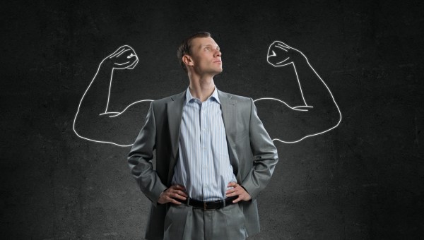 Mężczyzna w garniturze z dorysowanymi rękami siłacza