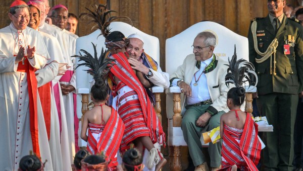 Pope Francis hugs a child alongside East Timor President's Jose Ramos-Horta (3R) during a welcoming ceremony at the Presidential Palace in Dili.