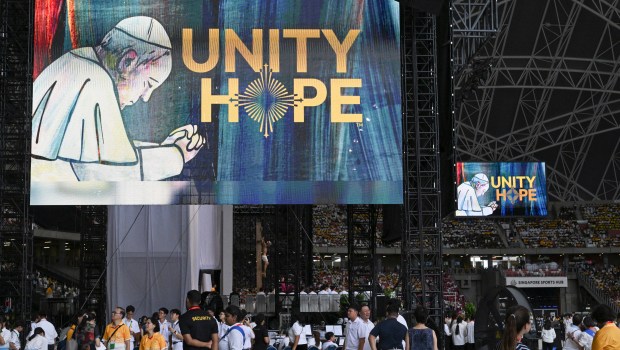 Catholic faithful wait to attend the holy mass led by Pope Francis at the National Stadium in Singapor