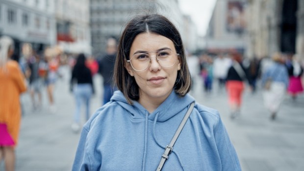 Poważna młoda kobieta w okularach patrzy na wprost