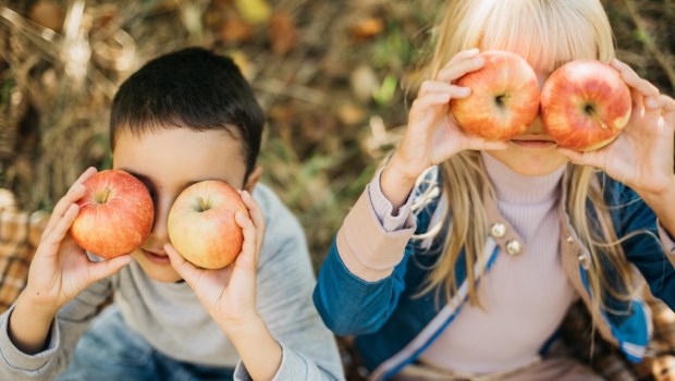 Dzieci z jabłkami. Trzymają je jak okulary