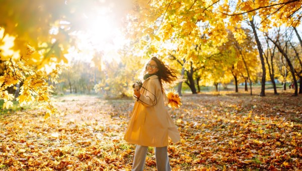 Uśmiechnięta kobieta w jesiennym lesie