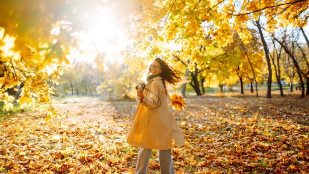 Uśmiechnięta kobieta w jesiennym lesie