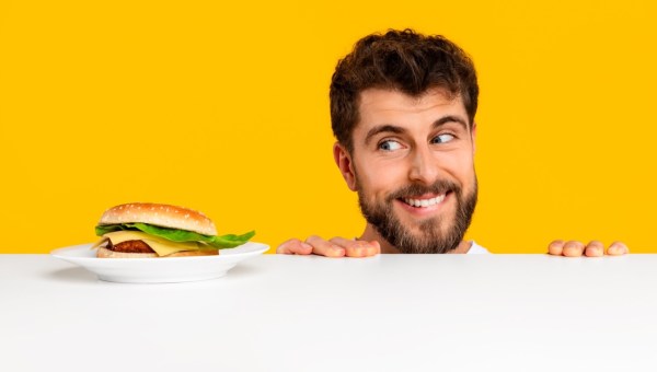 Mężczyzna z uśmiechem patrzy na kanapkę